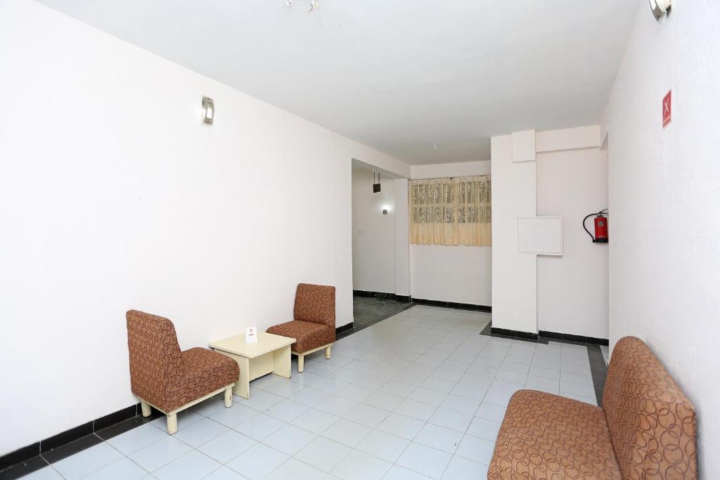 a hallway with chairs and a table in a room at Hotel O Midtown in Raipur