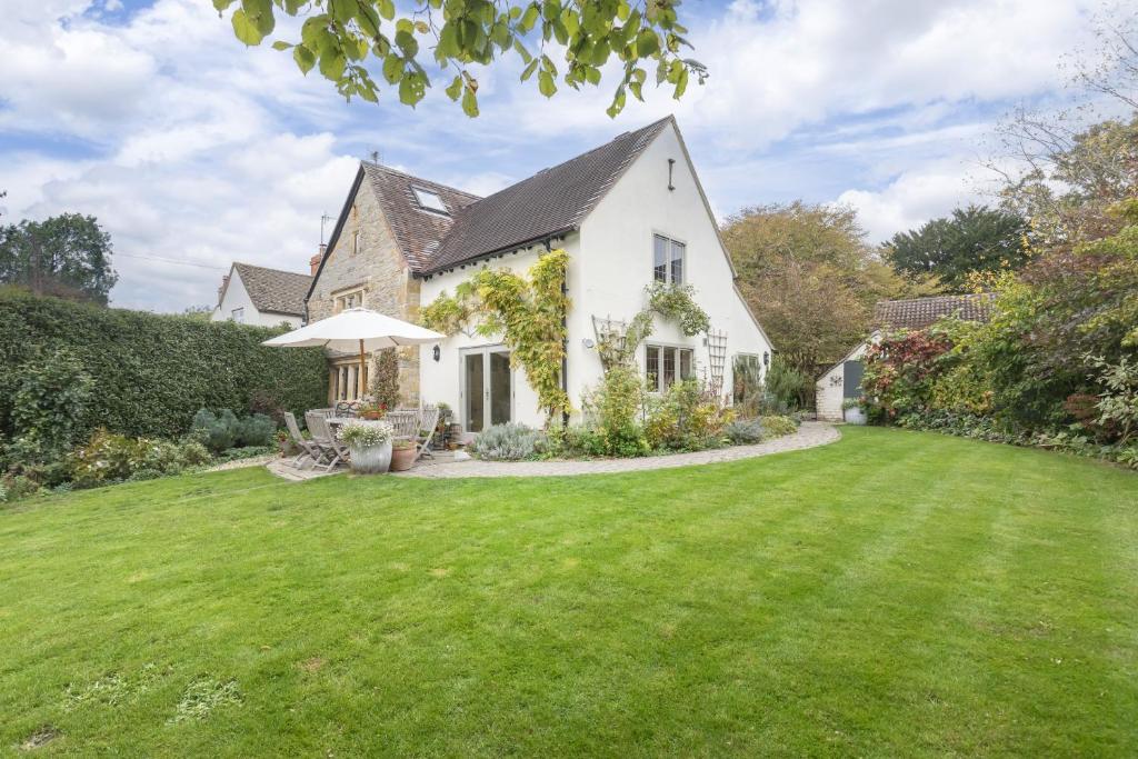 a white house with a green lawn at Idyllic Cotswold Cottage Near Broadway in Badsey