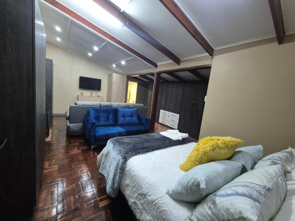 a living room with a bed and a blue couch at Modern Van Riebeeck Park Accomodation in Worcester
