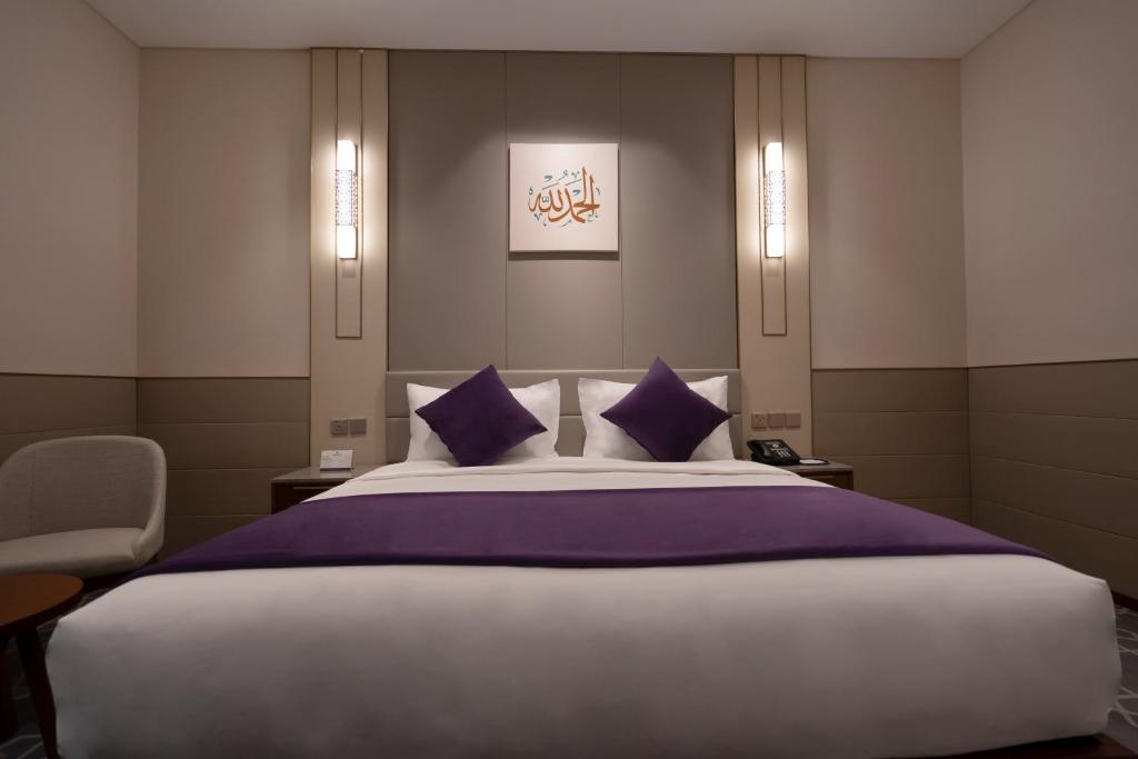 Un dormitorio con una cama grande con almohadas moradas. en Diar Alkhalidiya Hotel فندق ديار الخالدية, en La Meca