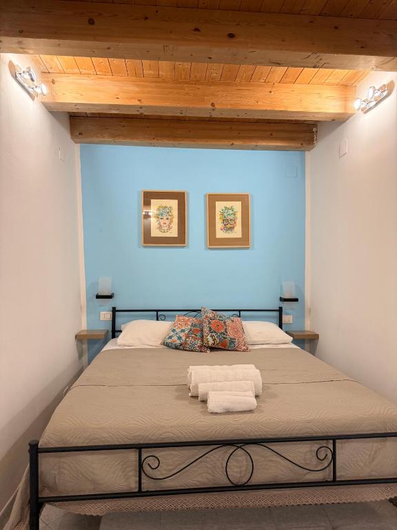 a bedroom with a large bed with two towels on it at Tanto di Cappello Home in Palermo