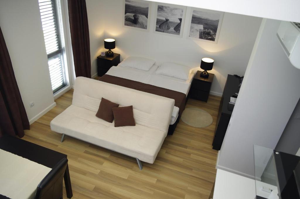 a bedroom with a bed and a white couch at Apartments Santis10 in Baška