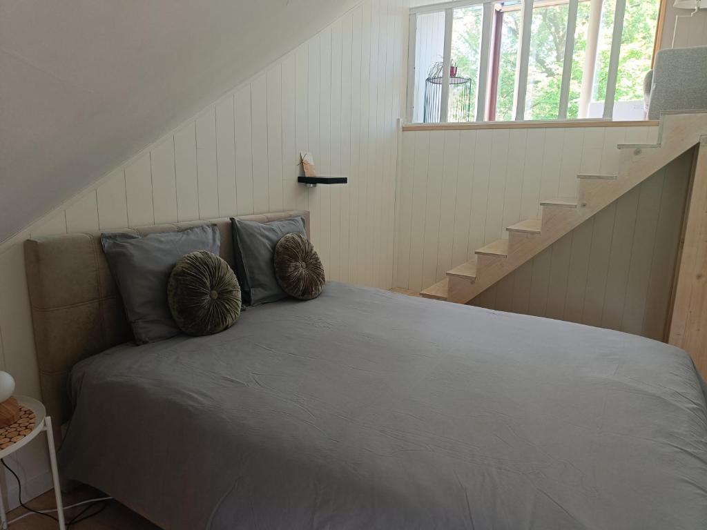 una cama en una habitación con escalera en B6, en Ursel