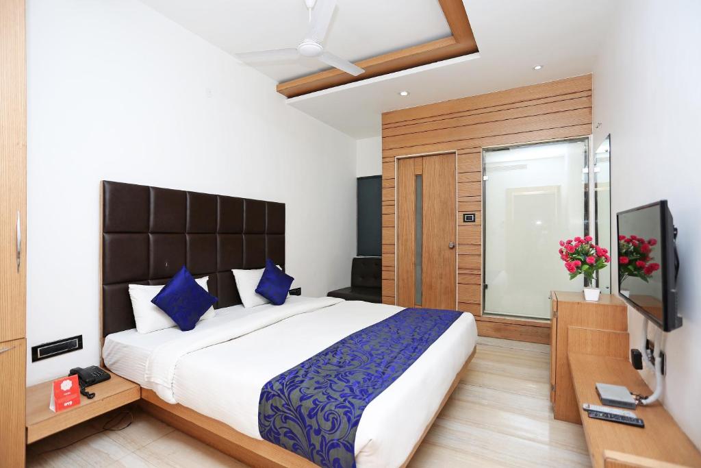 a bedroom with a large bed and a television at Collection O Sun Park in Bhopal