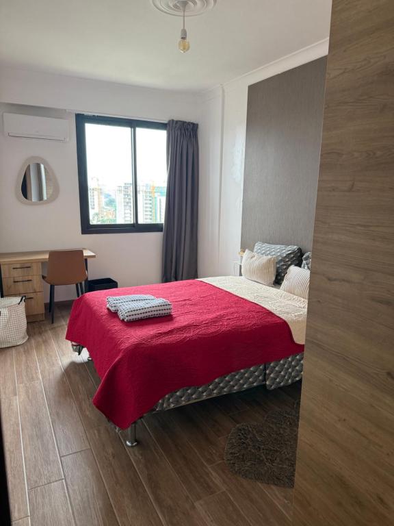 Un dormitorio con una cama con una manta roja. en Belle vue, en Abiyán