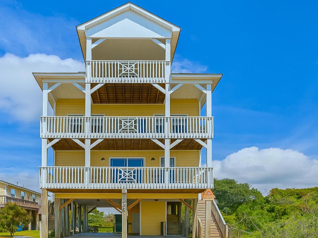 un alto edificio giallominio con un balcone di Lovin Lowe Tide a Thomas Landing
