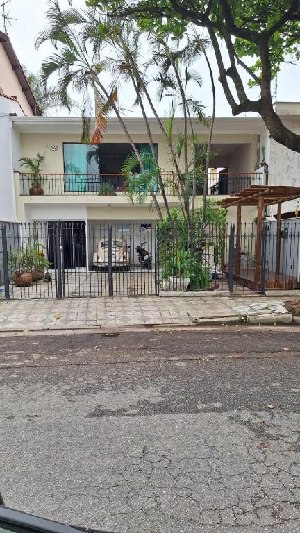 a fence in front of a house with a balcony at Pousada Lua Nova in Sorocaba