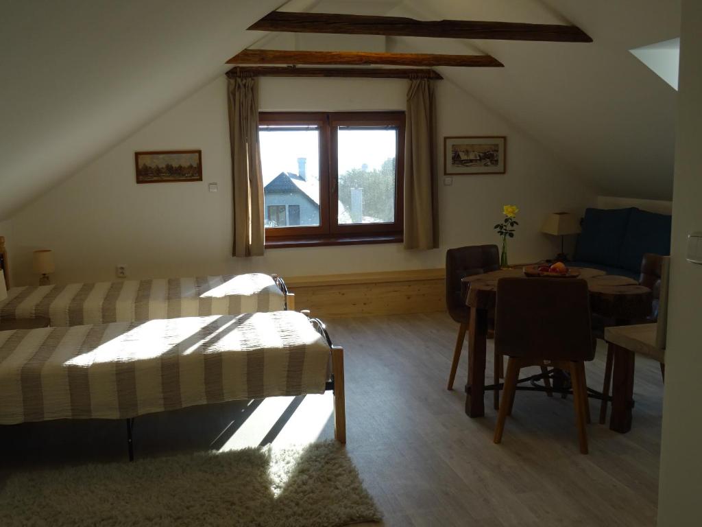 a room with a bed and a table and a window at Na půdě in Pohořany