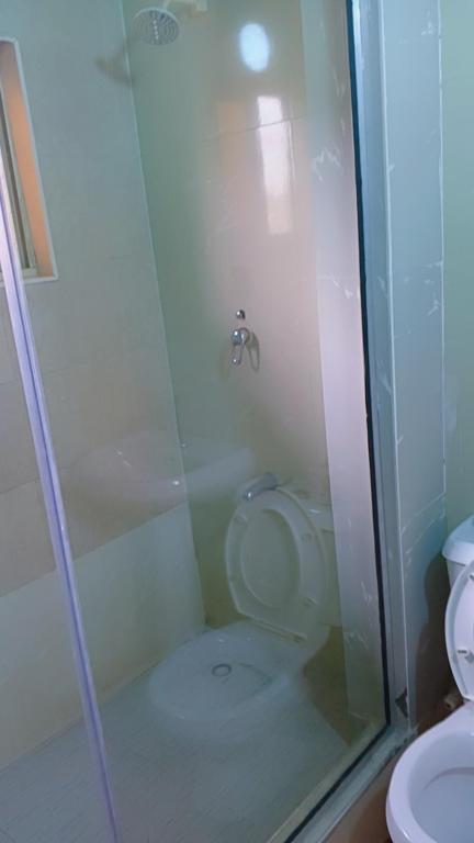 a bathroom with a shower with a toilet and a sink at Royale Signature in Lagos