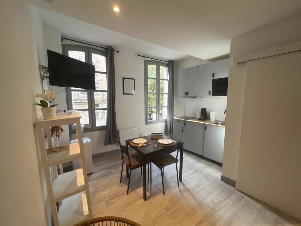 una cucina con un tavolo e sedie in una stanza di Pia - Studio 1er climatisé 2 pers ad Avignone