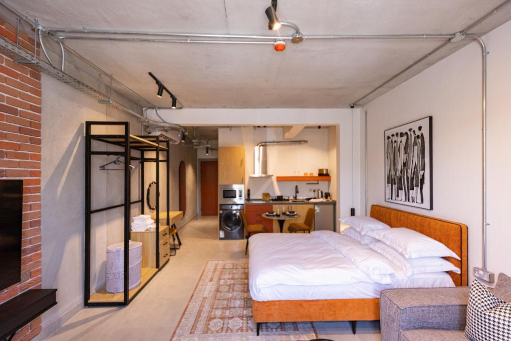 a bedroom with a large bed and a kitchen at C Living 3 - Al Malqa in Riyadh