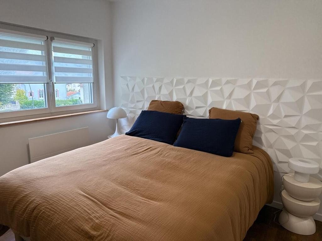 a bedroom with a large bed with blue pillows at Le Trente 9 in Neufchâteau