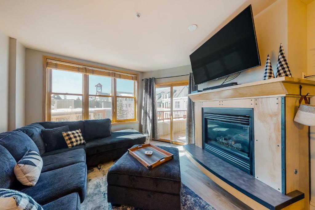 a living room with a couch and a fireplace at Silvermill Lodge 8285 in Keystone