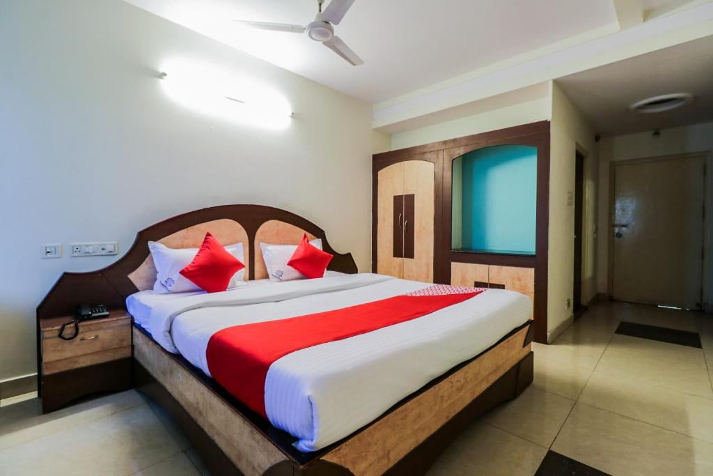a bedroom with a large bed with red pillows at Super Hotel O Parnasala Princely in Rājahmundry