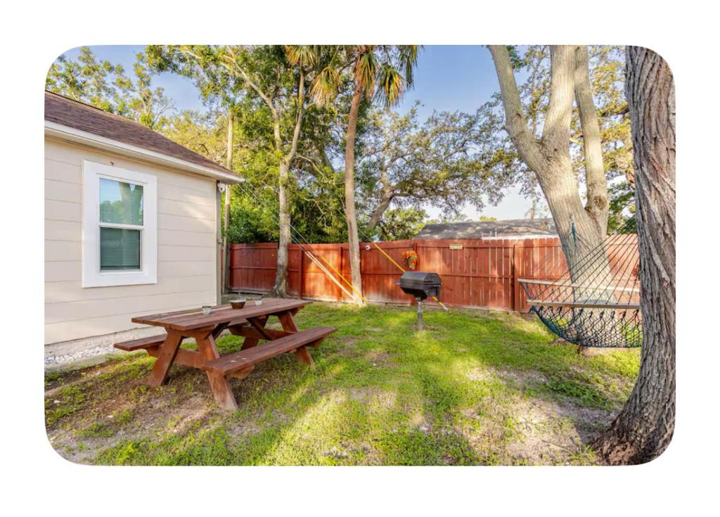 a picnic table and a grill in a backyard at Seashell & Sunshine Lodge in St Petersburg