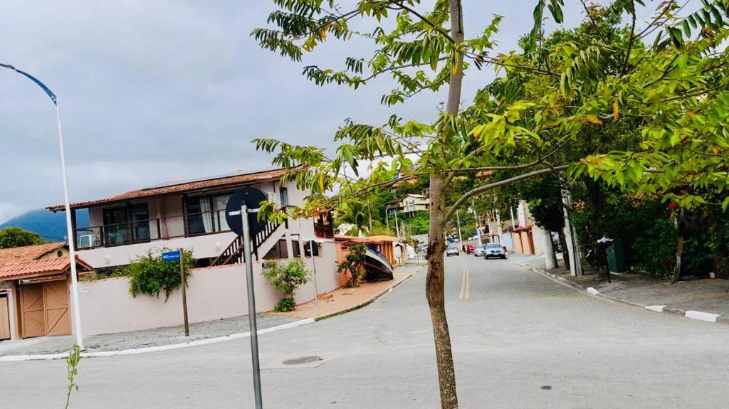 a street with a tree in front of a building at Chalé em Ilhabela 02 in Ilhabela