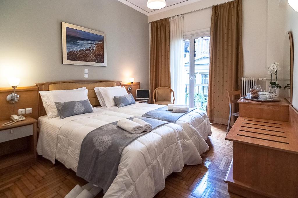 - une chambre avec un grand lit et 2 serviettes dans l'établissement Ares Athens Hotel, à Athènes