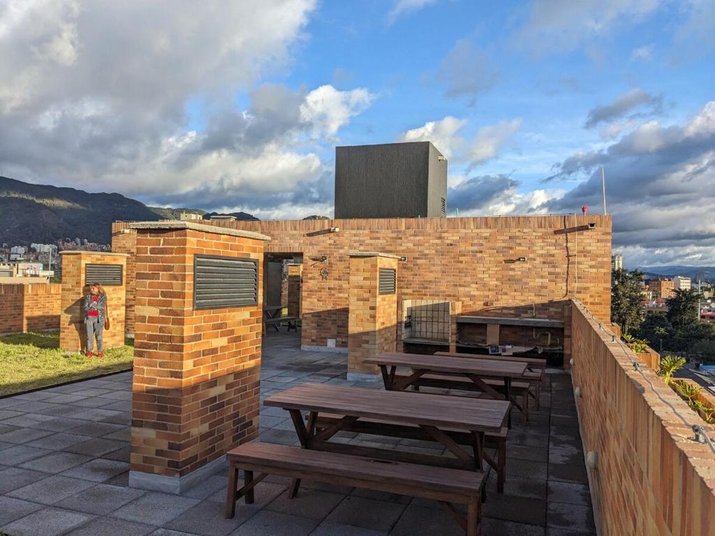 a brick building with picnic tables on a patio at Encantador apartaestudio Charming studio apartment in Bogotá