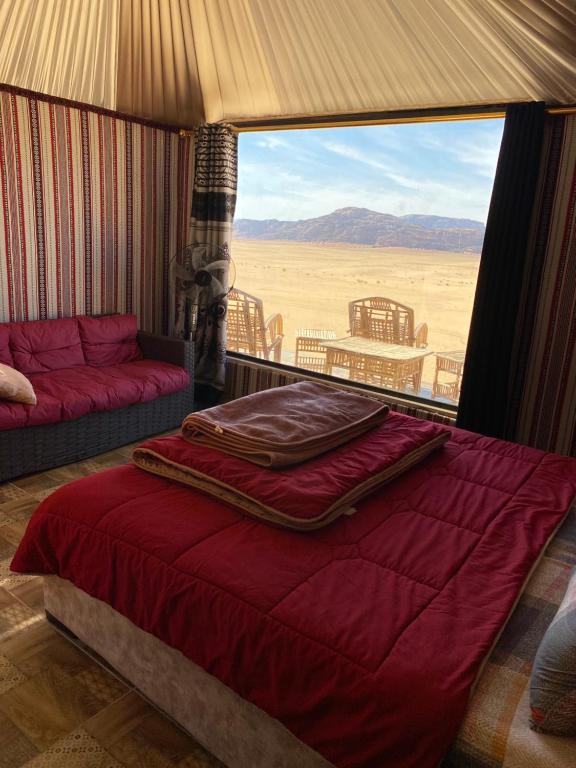 a bed in a room with a view of the desert at Rum ahmad in Wadi Rum