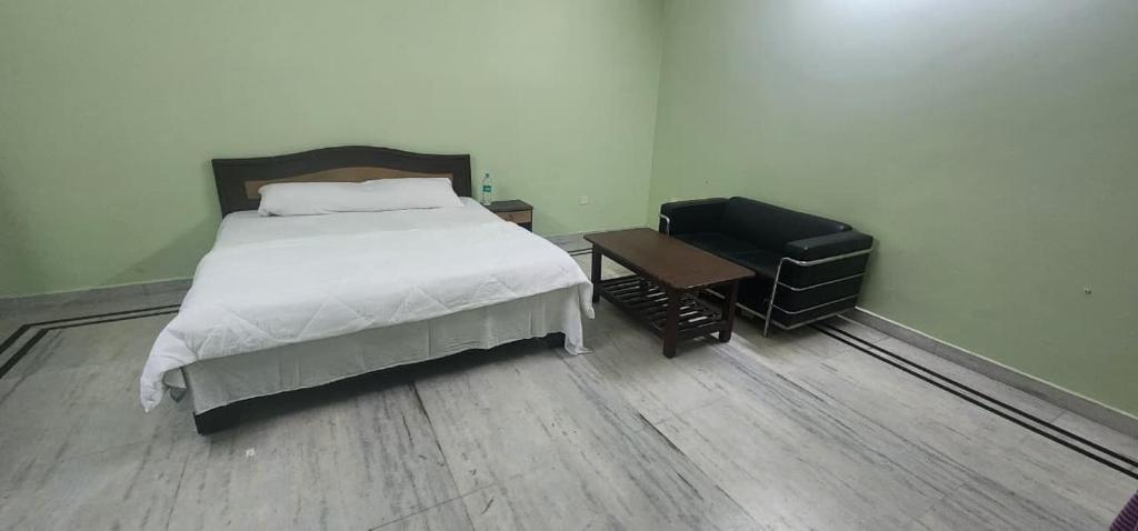 a bedroom with a bed and a desk and a chair at Chetiya Farmhouse in Paikbara