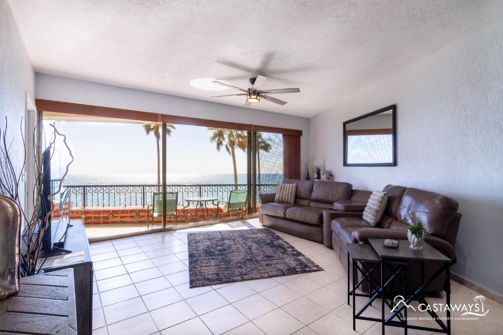 a living room with a couch and a view of the ocean at Sonoran Spa E204 in Puerto Peñasco