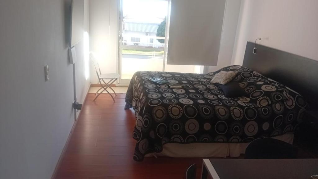 a bedroom with a bed in a room with a window at Colina Garden departamento in Victoria