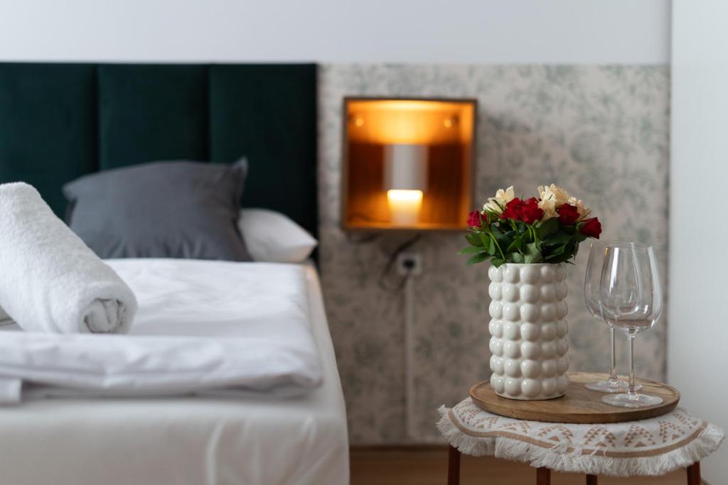 a bedroom with a bed and a vase with flowers on a table at Wonderful Apartments in the Center of Krakow in Kraków