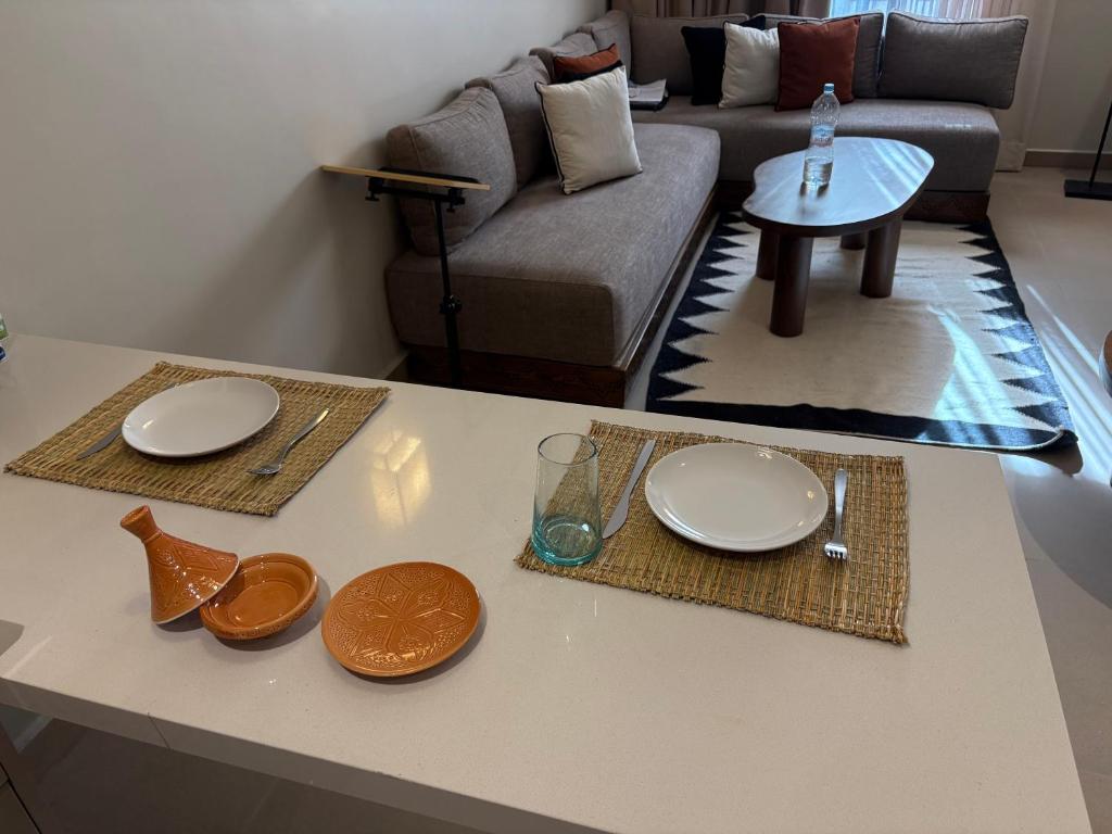 a living room with a table with plates on it at Dally Apart Hotel in Rabat