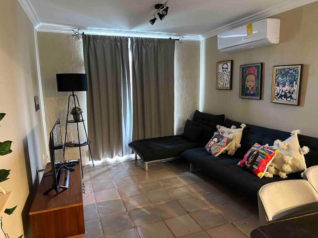 - un salon avec un canapé noir dans l'établissement Downtown Cancun Accommodation, à Cancún