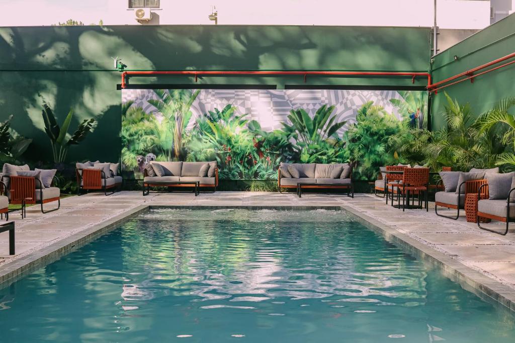 einen Pool mit Liegestühlen und eine Terrasse in der Unterkunft ArtHotel Transamerica Collection in Porto Alegre