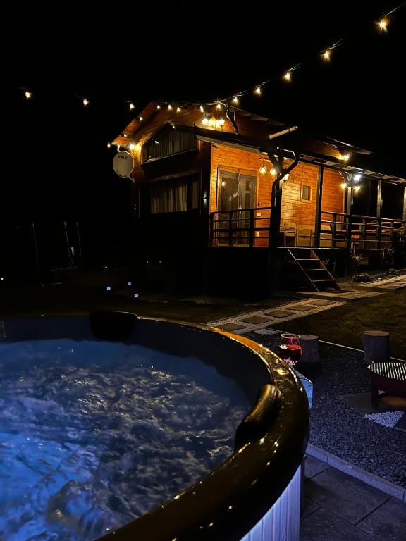 a house with a large swimming pool at night at Recele Tiny Nest in Ilva Mare