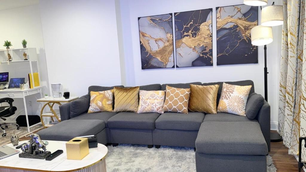 a living room with a couch and a table at Spacious Private Ensuite, With Private Bath, Outdoor Space, Workstation, Gym, & All Utilities Included in Point Breeze Home in Philadelphia