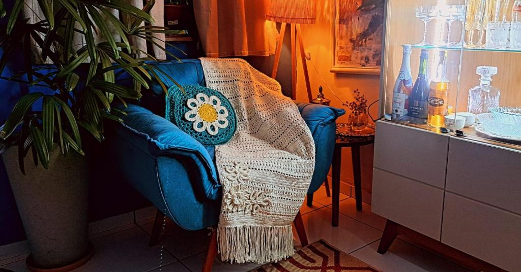a blue chair with a blanket on it next to a plant at Casa do Edinho in Belém