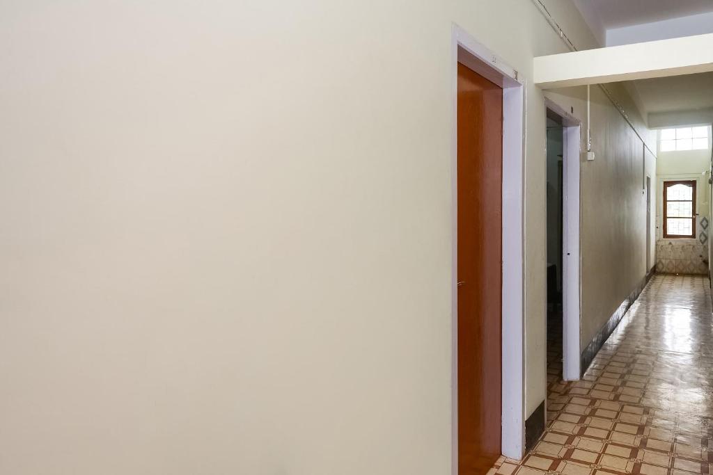 an empty hallway of a building with a tile floor at Hotel O Kirtti Inn in Soalkuchi