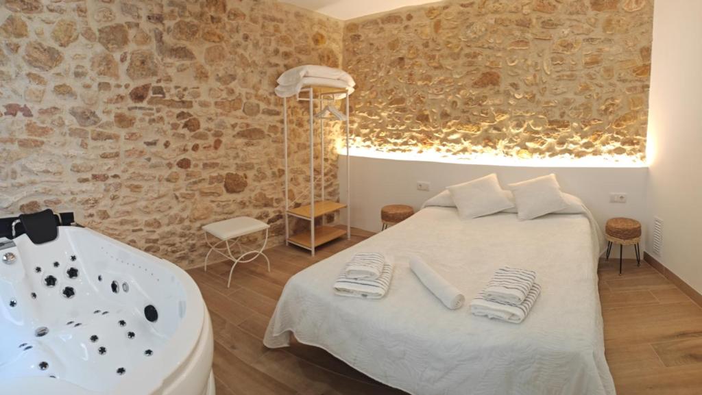a bedroom with a tub and a bed with towels at La Casa del Campanar in Traiguera