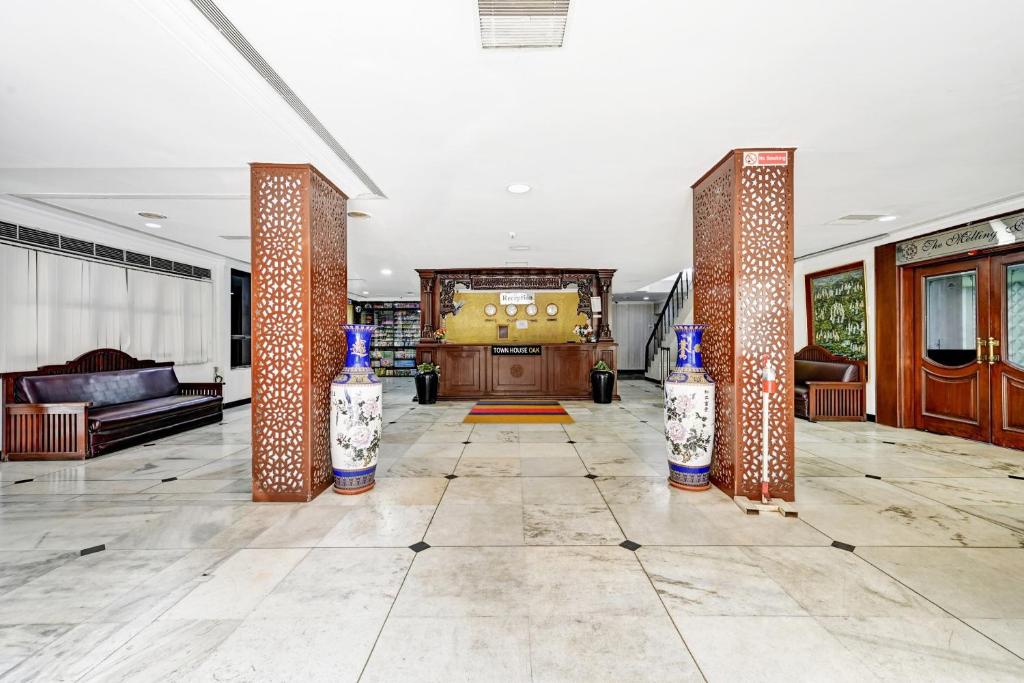 a living room with a lobby with pillars and a door at Townhouse OAK Hotel Belsons Taj Mahal in Hyderabad