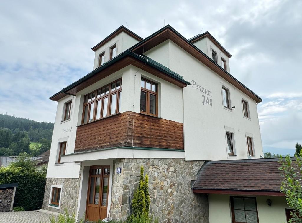 扬斯凯拉兹涅Penzion Jas的一栋白色房子，屋顶是棕色的。