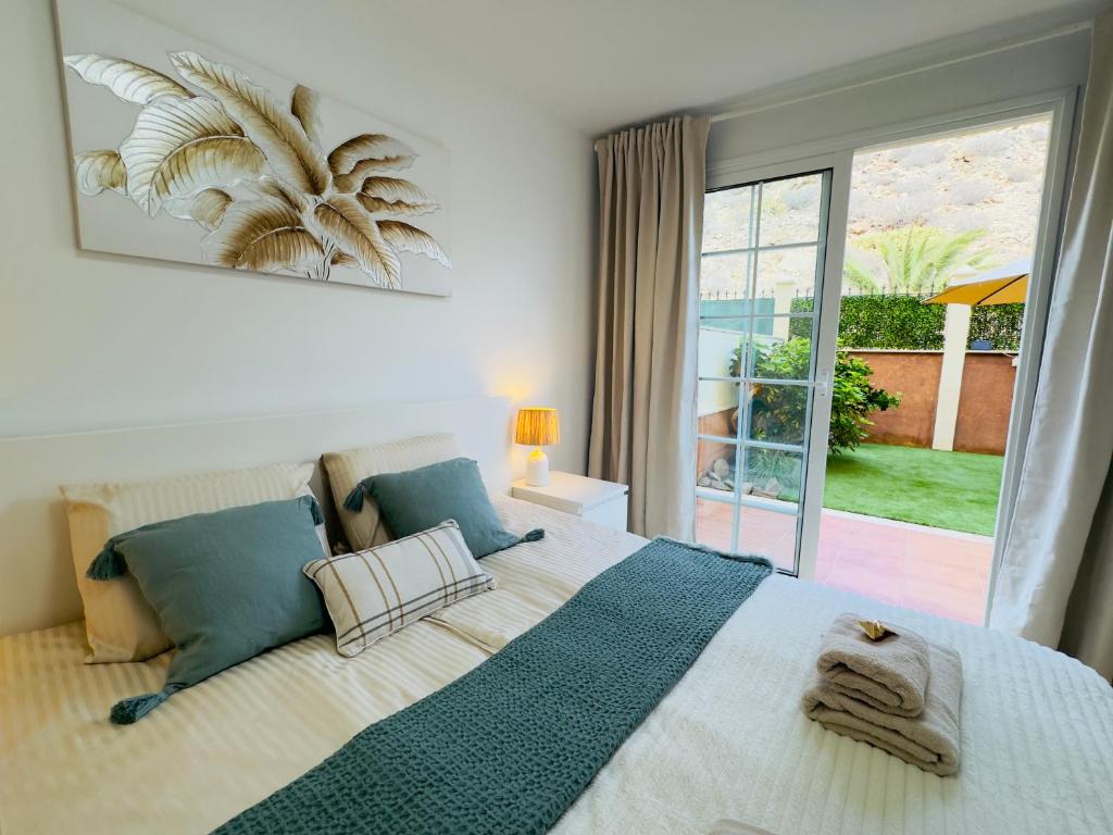 a bedroom with a large bed and a large window at Bright Retreat with Lush Outdoor Space in Palm-Mar