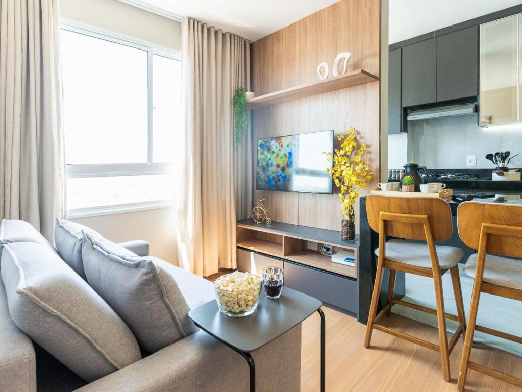 a living room with a couch and a table and a kitchen at Apartamento sofisticado c vaga e vista Arena MRV in Belo Horizonte