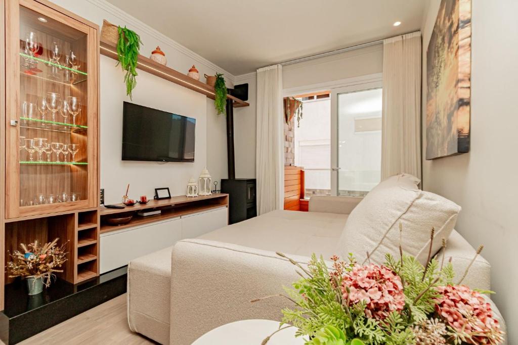 a living room with a bed and a tv at Ótima localização - @stayhousetemporada in Canela