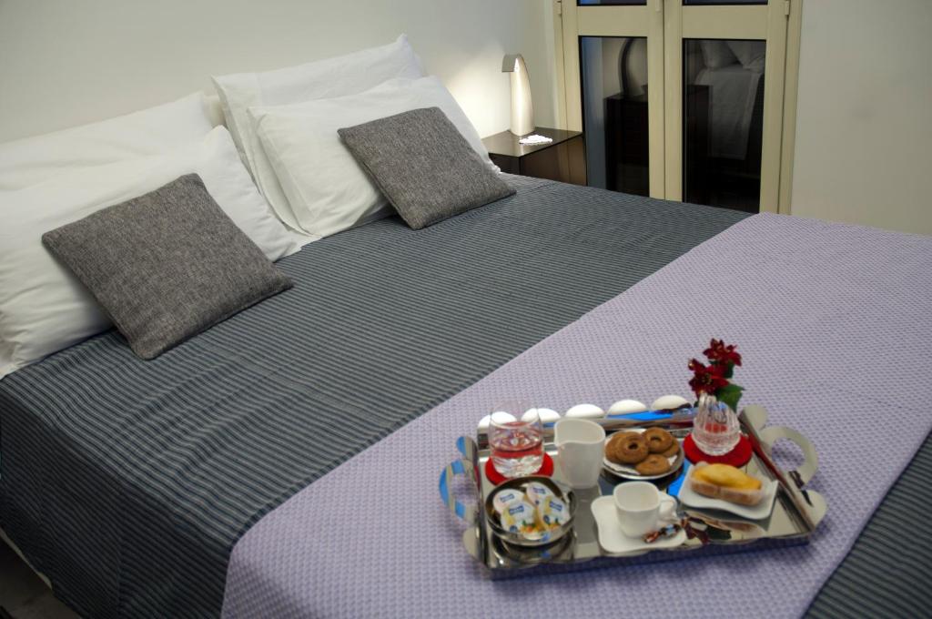 Una cama con una bandeja de comida. en SunMoon, en Reggio Calabria