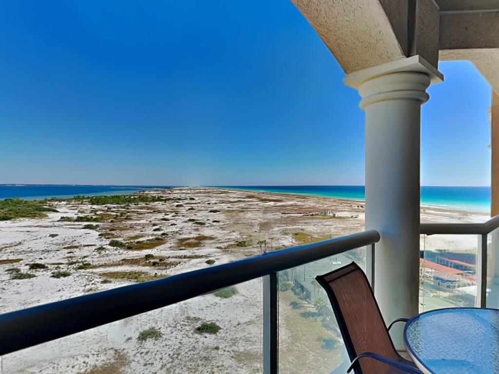 a balcony with a table and chairs and the ocean at Portofino Island Resort #2-1002 in Pensacola Beach