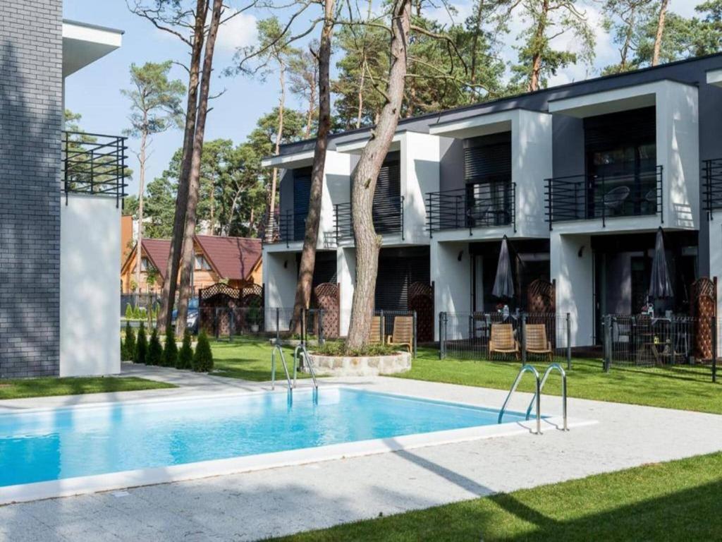 a house with a swimming pool in front of it at Comfortable holiday home with garden, summer pool in Pobierowo