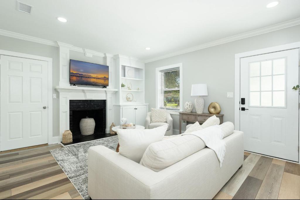 Sala de estar blanca con sofá blanco y chimenea en Southern charm, en Charleston