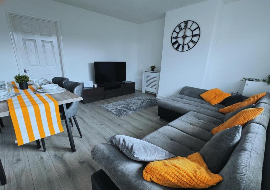 KingsthorpeにあるHome In Northamptonのソファとテーブルのあるリビングルーム