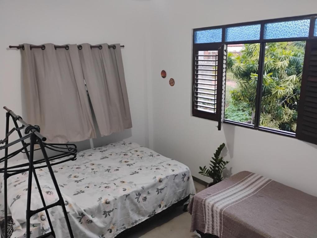 a bedroom with a bed and a window at Hospedaria Su in Parnamirim