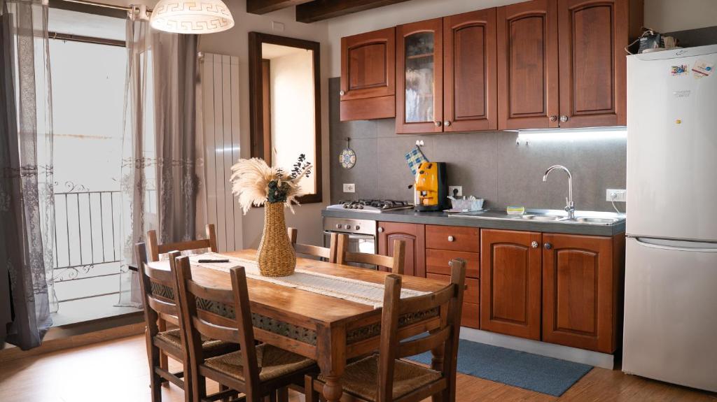 Una cocina con una mesa de madera y un refrigerador. en Appartamento in Centro Storico a Termini Imerese - Eden Holiday Home, en Termini Imerese