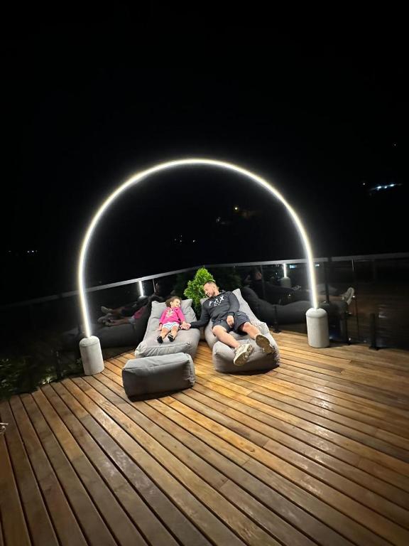 a man and a child laying on pillows on a deck at Suíte Itaipava in Araras Petropolis