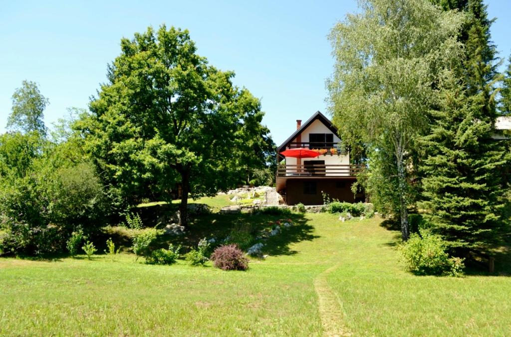 a house in the middle of a field with trees at Holiday House Mrežnički gaj in Galović-Selo