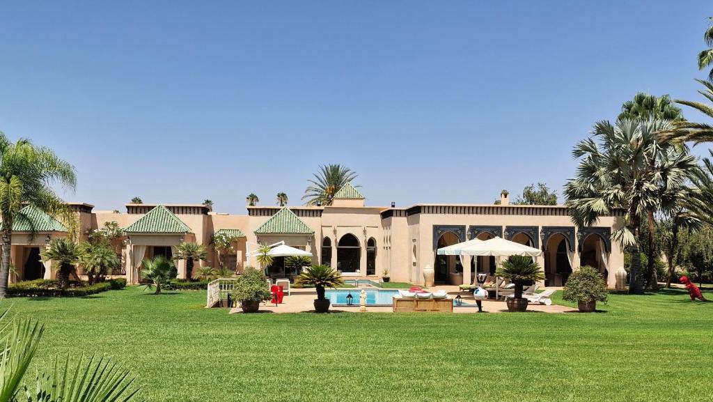 a large house with a pool and a yard at Villa Alcázar Marrakech in Had Abdallah Rhiat